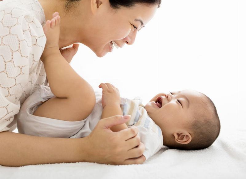 Người đang dùng khăn giấy ấm lau nhẹ nhàng vùng hậu môn của mèo con sau khi bú, minh họa việc kích thích đi vệ sinh
